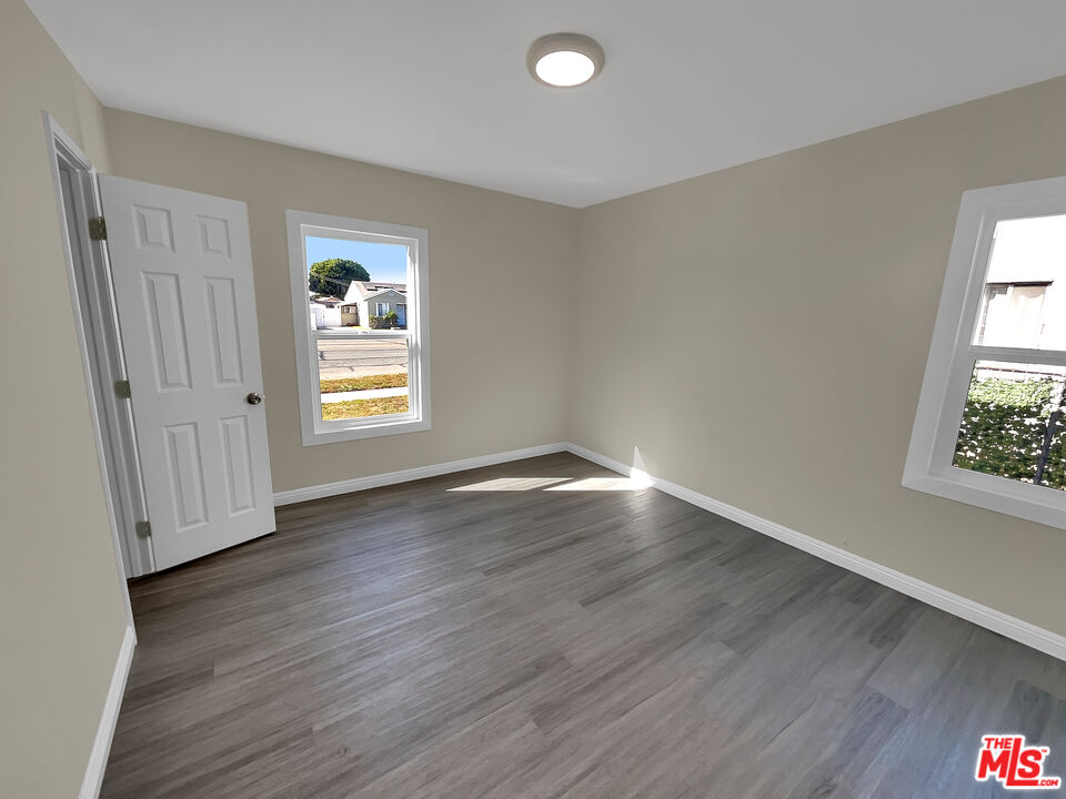 14538 Atlantic Avenue Compton, CA 90221 - Photo 5 of 18 an empty room with wooden floor and windows