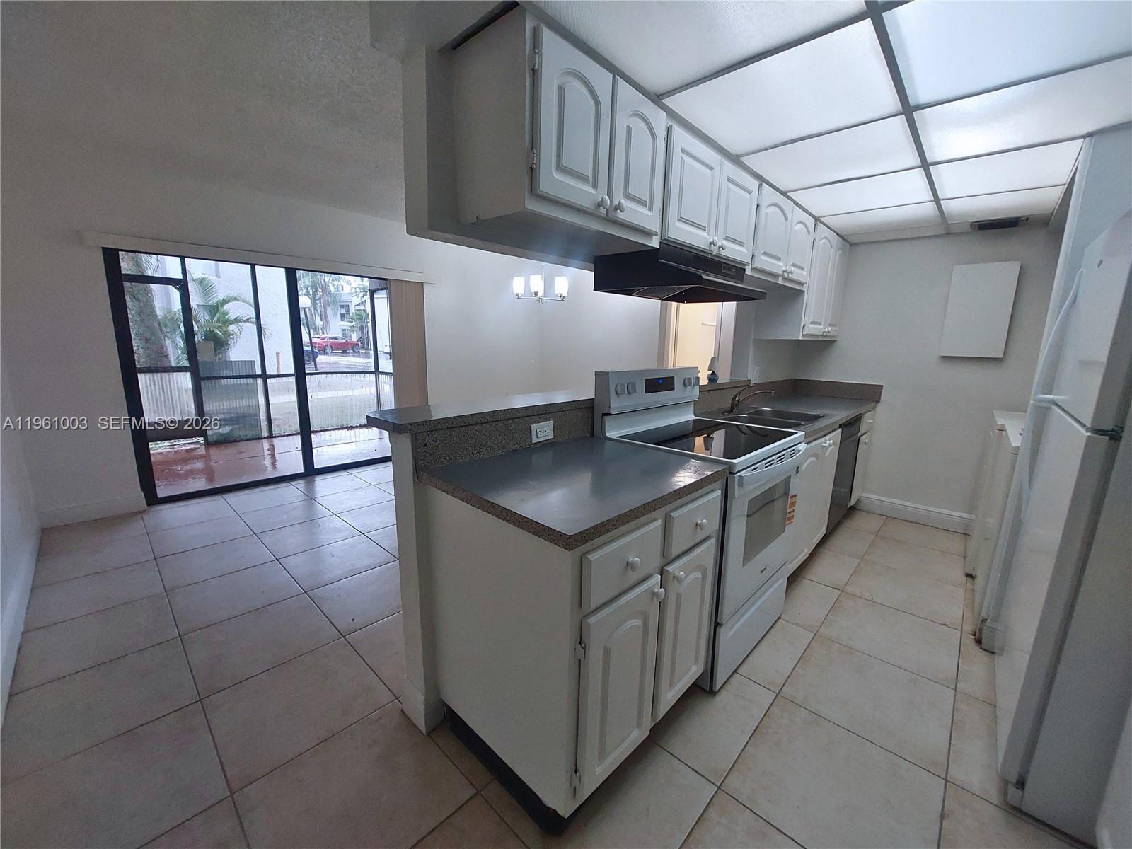 4463 Treehouse Lane, Unit D Tamarac, FL 33319 - Photo 2 of 14 a kitchen that has a sink a stove and a microwave oven