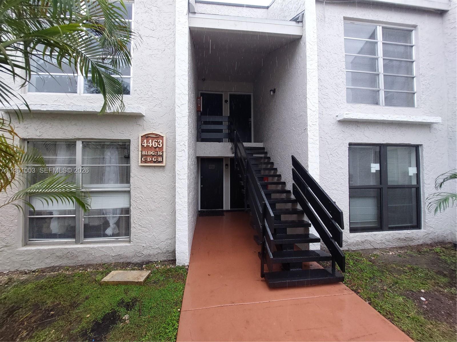 4463 Treehouse Lane, Unit D Tamarac, FL 33319 - Photo 3 of 14 a front view of a house with a yard