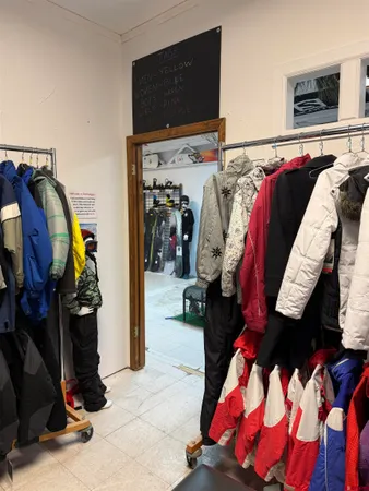 a walk in closet with clothes and shoes