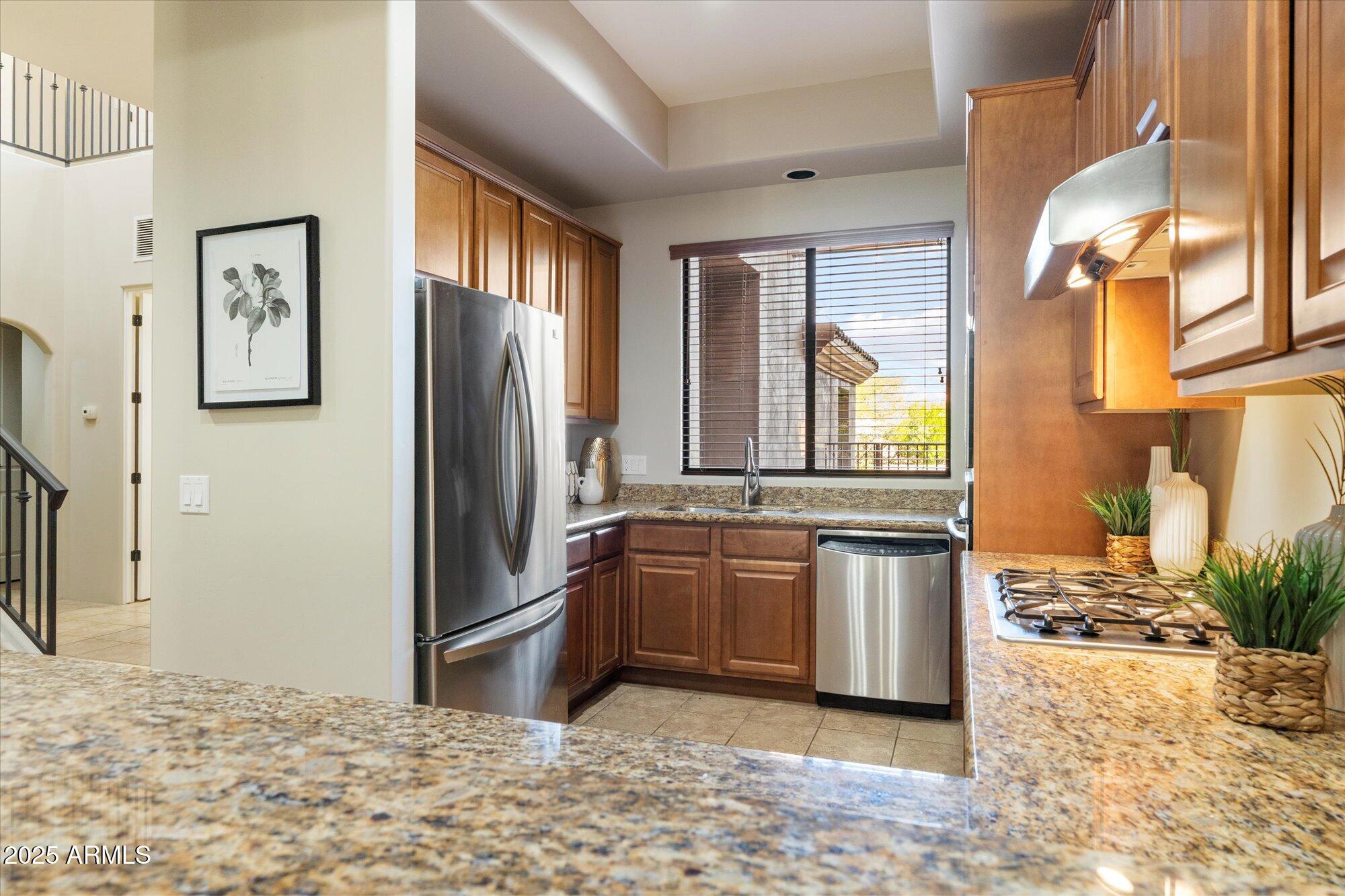 7200 East Ridgeview Place, Unit 9 Carefree, AZ 85377 - Photo 11 of 29 a kitchen with stainless steel appliances granite countertop a refrigerator sink and stove