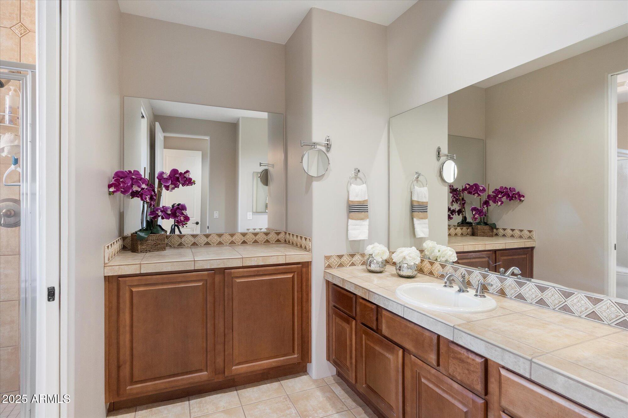 7200 East Ridgeview Place, Unit 9 Carefree, AZ 85377 - Photo 22 of 29 a bathroom with a granite countertop sink a large mirror and vanity