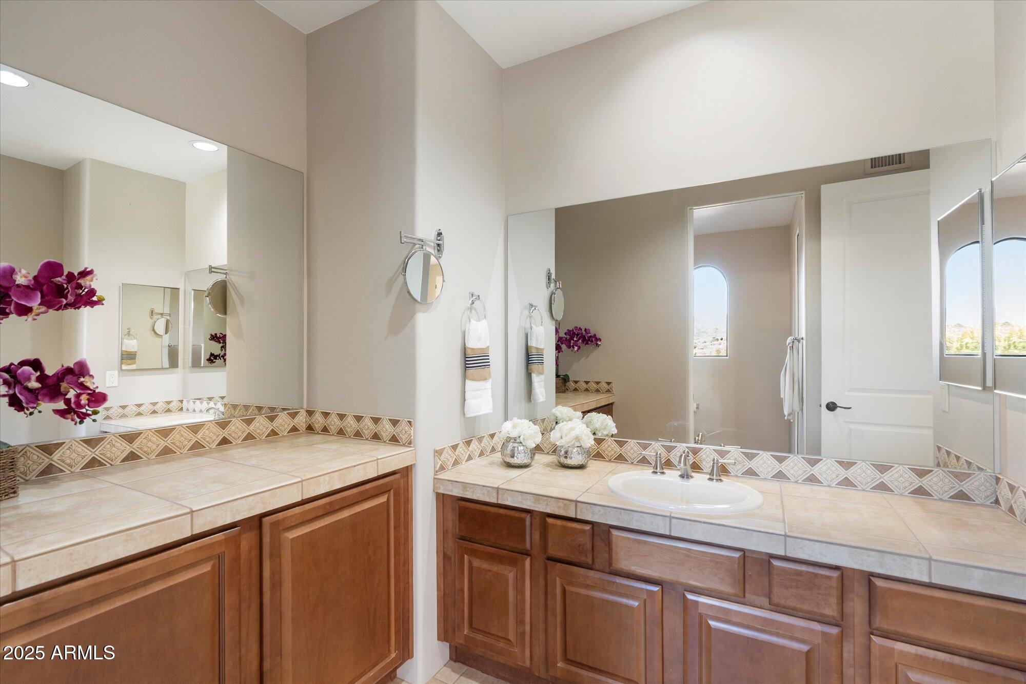 7200 East Ridgeview Place, Unit 9 Carefree, AZ 85377 - Photo 23 of 29 a bathroom with a granite countertop sink and a mirror