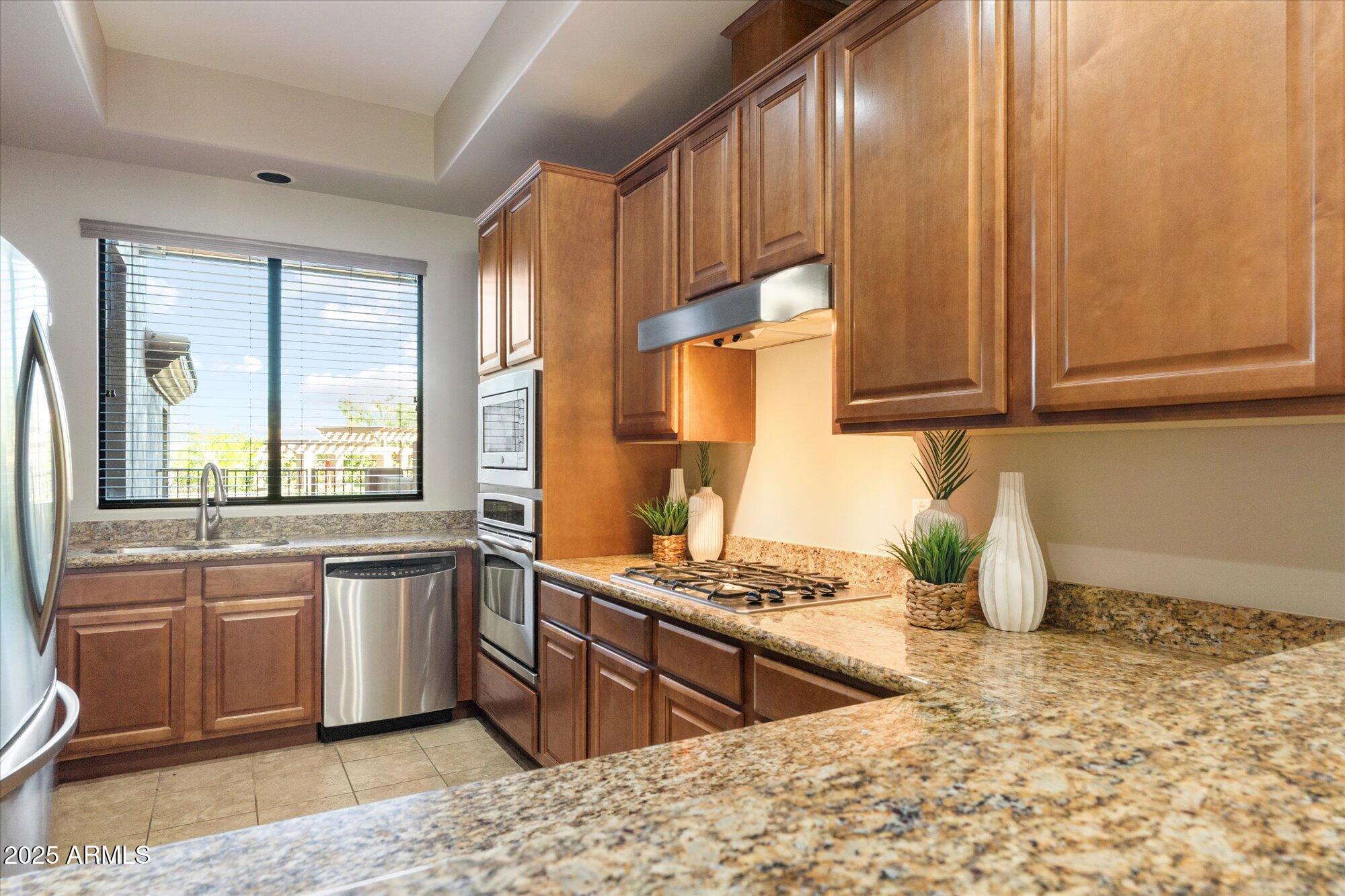 7200 East Ridgeview Place, Unit 9 Carefree, AZ 85377 - Photo 3 of 29 a kitchen with stainless steel appliances granite countertop a sink stove and cabinets