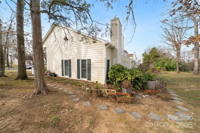 a view of a house with backyard and trees