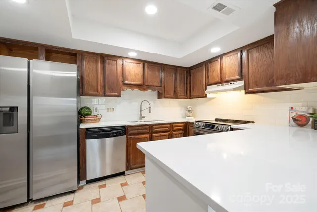 a kitchen with stainless steel appliances granite countertop a refrigerator a sink a stove a microwave and island