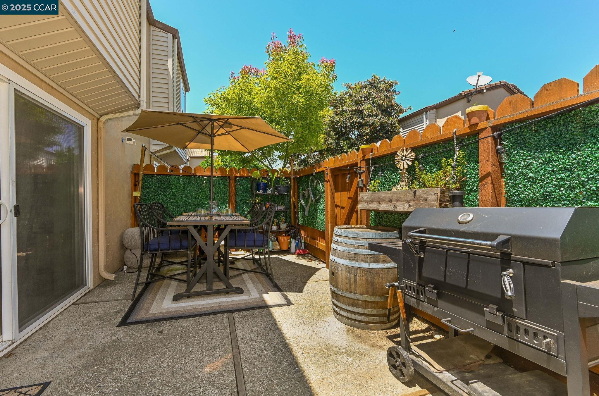 1435 Bel Air Drive, Unit C Concord, CA 94521 - Photo 18 of 25 a view of a patio with table and chairs under an umbrella with a small yard