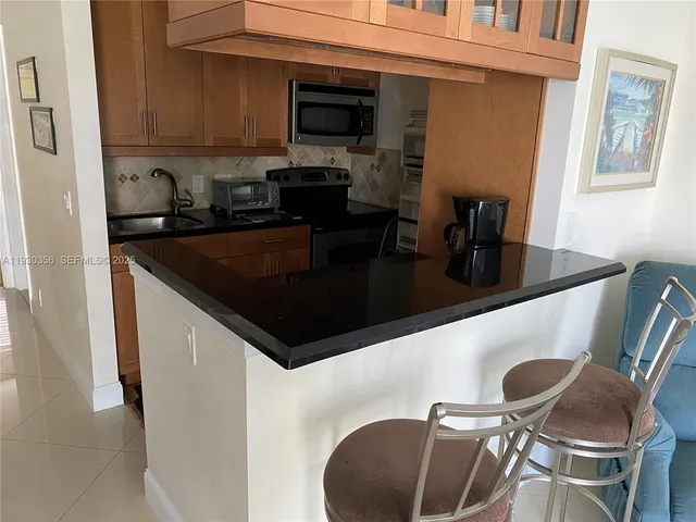 a kitchen with stainless steel appliances granite countertop a sink and a refrigerator
