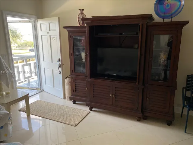 a living room with a dresser and a flat screen tv