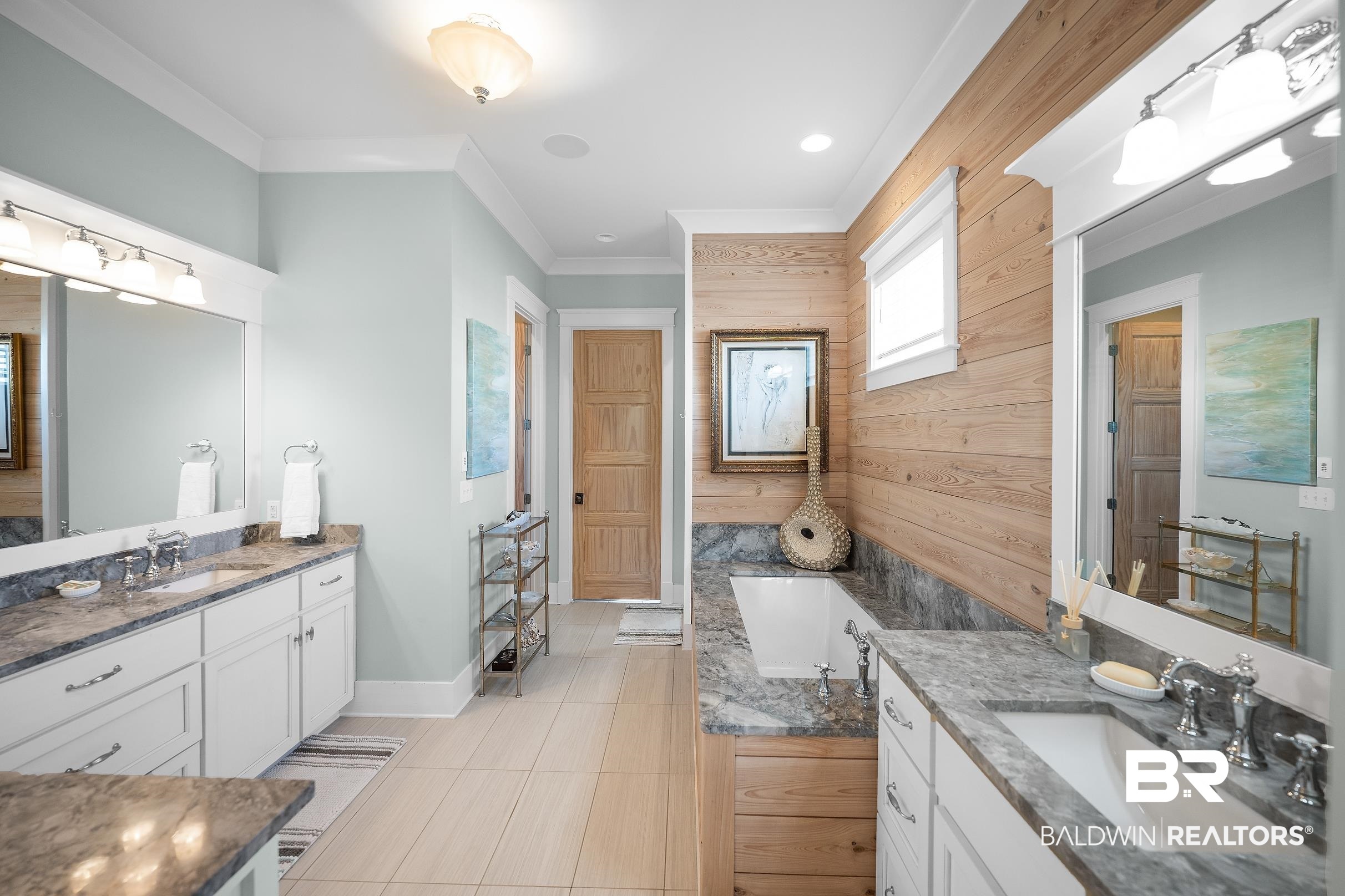 33186 Marlin Key Drive Orange Beach, AL 36561 - Photo 50 of 87 Full bathroom featuring two vanities, ornamental molding, wooden walls, and a tub to relax in