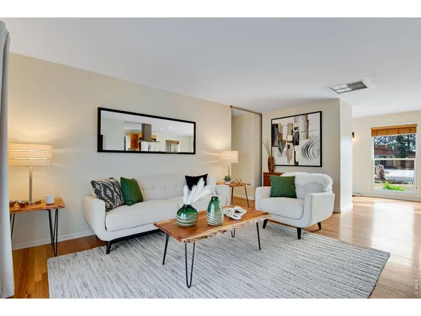 a living room with furniture and wooden floor
