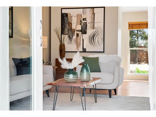 a living room with furniture and a painting on the wall