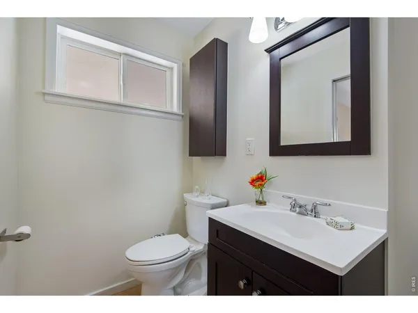 a bathroom with a sink vanity mirror and toilet