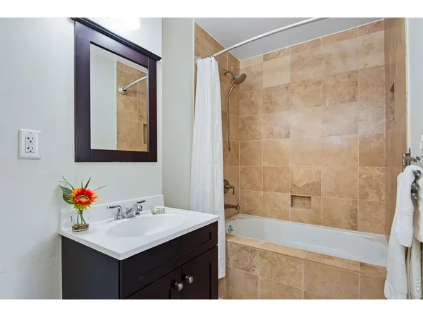 a bathroom with a sink mirror and a shower