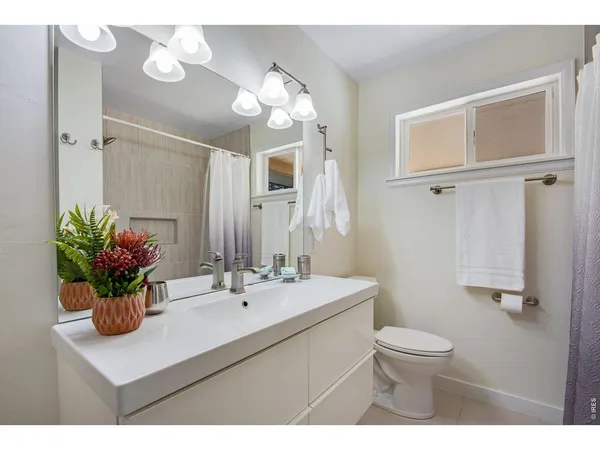 a bathroom with a sink a toilet and mirror