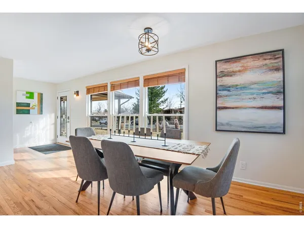 a dining room with furniture and a large window