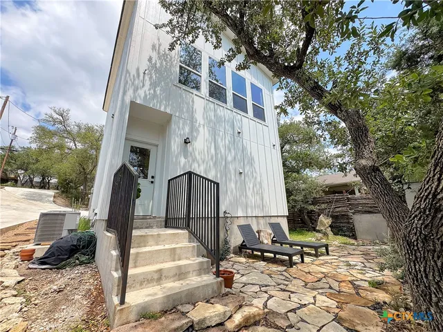 a view of a brick house with large windows and a tree