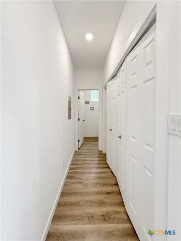a view of a hallway with wooden floor and staircase