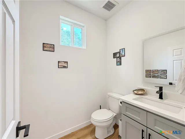 a bathroom with a sink mirror vanity and a toilet