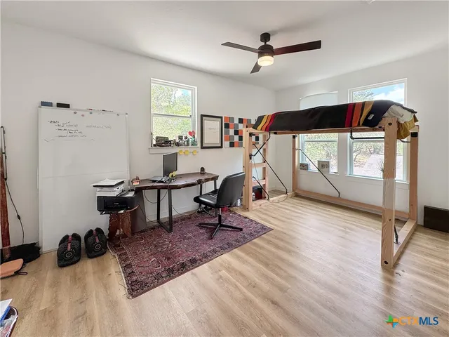 a view of a livingroom with wooden floor and a ceiling fan