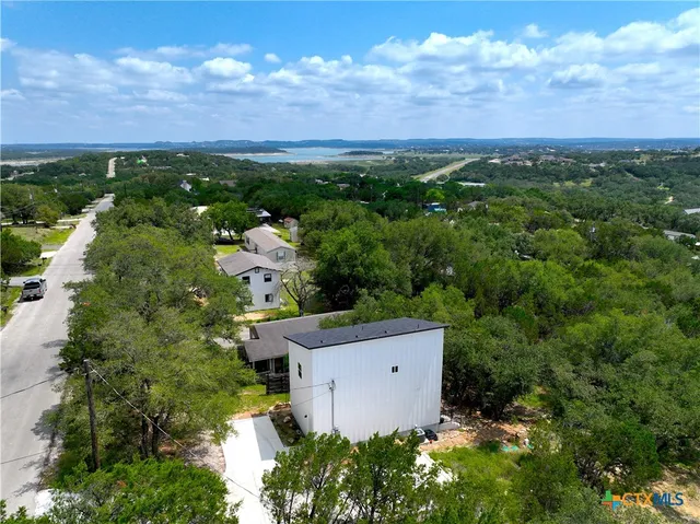 a backyard of a house with table and chairs under an umbrella