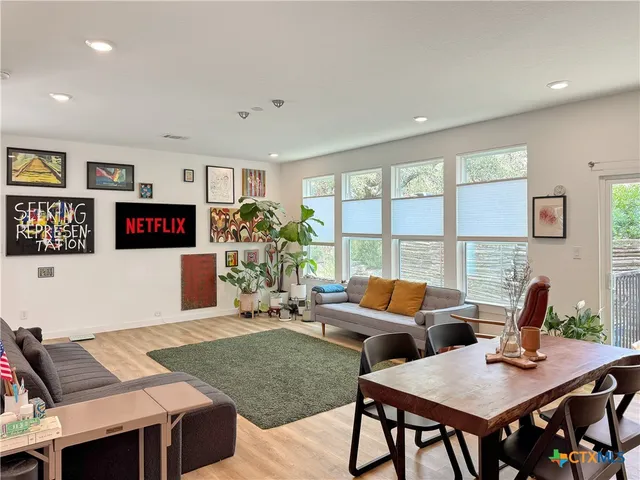 a living room with furniture a flat screen tv and a large window