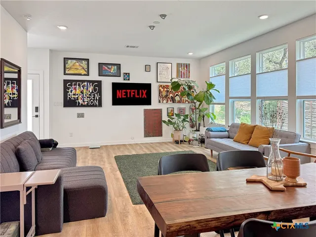 a living room with furniture a flat screen tv and a large window