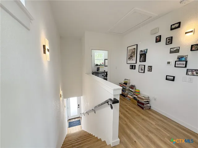 a view of a livingroom with wooden floor and stairs