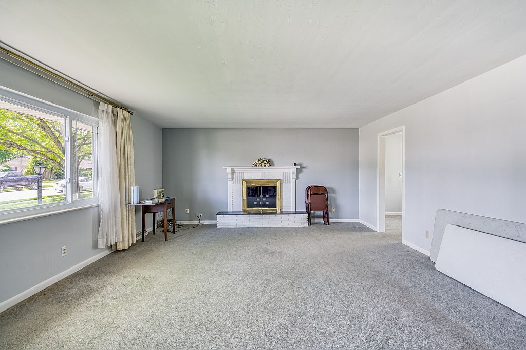 324 Beckenham Road Englewood, OH 45322 - Photo 5 of 26 Bright and open living area with a classic fireplace, perfect for cozy gatherings.