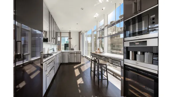 a kitchen with stainless steel appliances kitchen island granite countertop a refrigerator a stove and a dining table with wooden floor