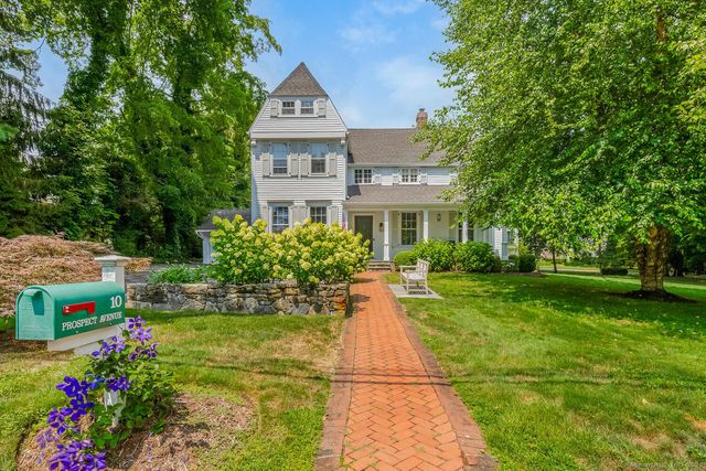 a front view of a house with a yard and fountain