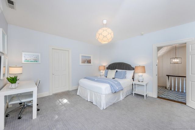 a bedroom with a bed and a lamp on dresser