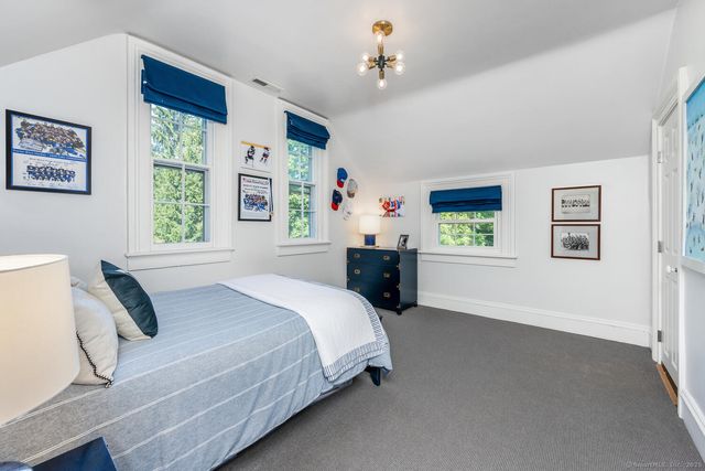 a bedroom with a bed dresser and window