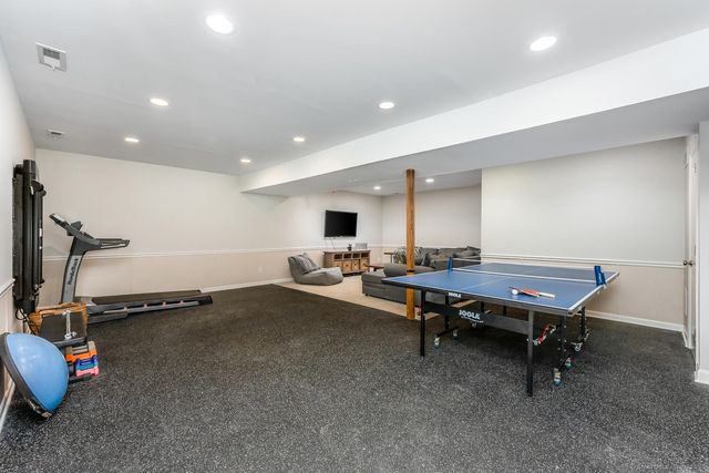 a living room with gym equipment and a flat screen tv