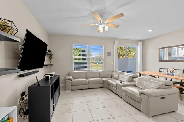 a living room with stainless steel appliances kitchen island a table and chairs