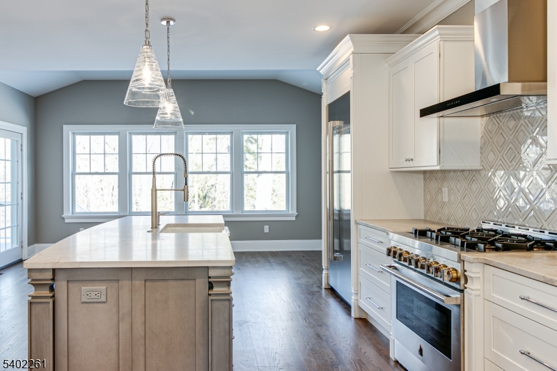 8 Juniper Pointe Trail Dunellen, NJ 08812 - Photo 23 of 37 a kitchen with kitchen island granite countertop a stove a sink a dining table and chairs with wooden floor