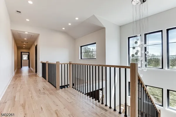 a view of a hallway with wooden floor and windows