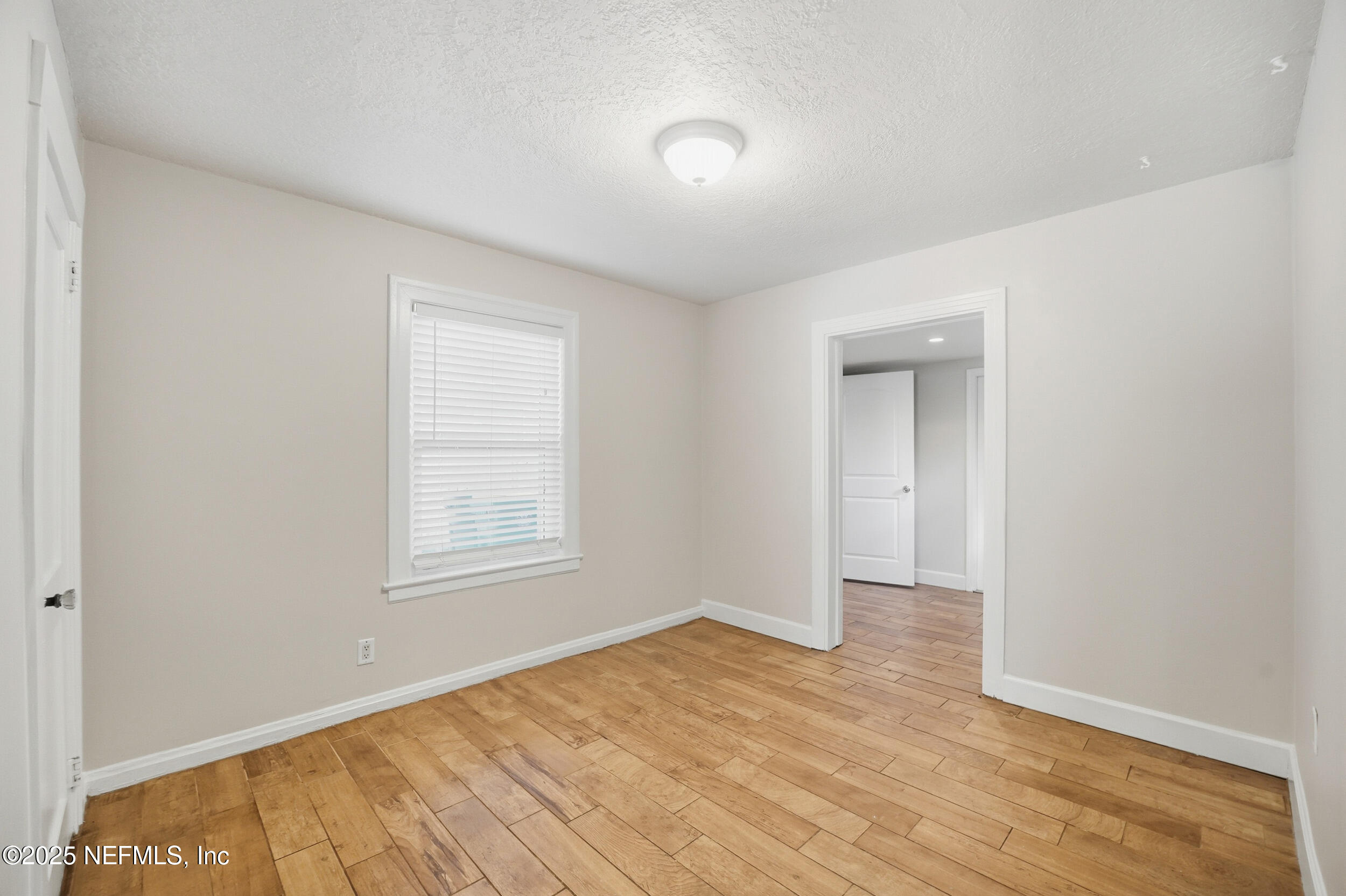 1211 Penman Road Jacksonville Beach, FL 32250 - Photo 16 of 44 an empty room with wooden floor and windows