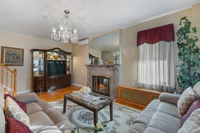 a living room with furniture a chandelier and a fireplace
