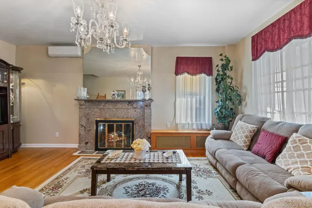 a living room with furniture chandelier and a fireplace