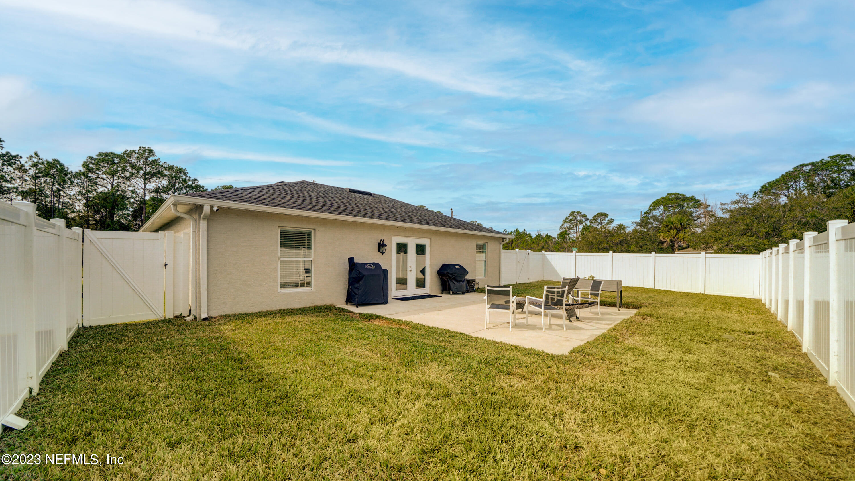 321 West Jayce Way St. Augustine, FL 32084 - Photo 25 of 34 a view of a patio with table and chairs and potted plants with wooden fence