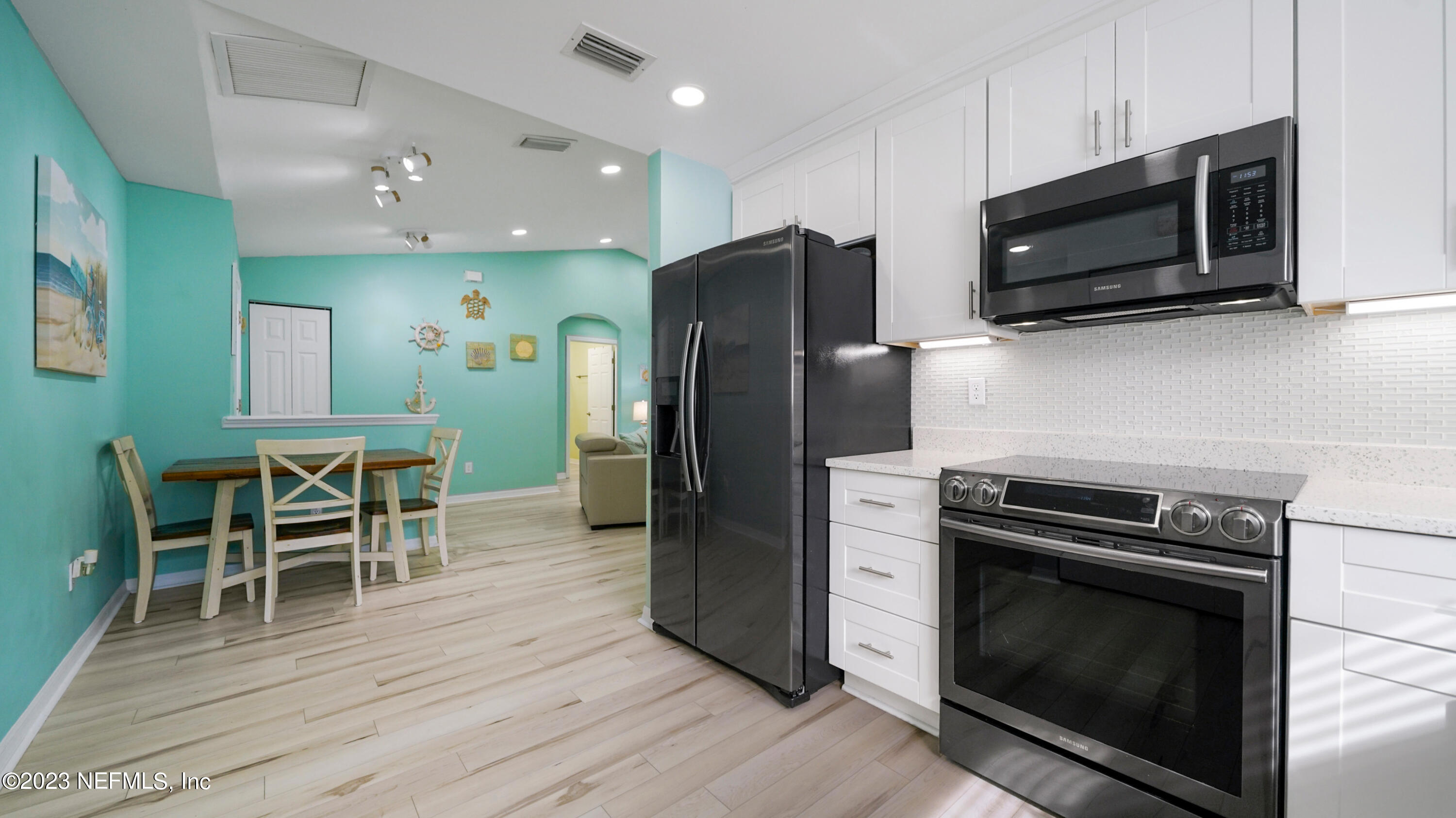 321 West Jayce Way St. Augustine, FL 32084 - Photo 10 of 34 a kitchen with stainless steel appliances wooden floor sink and microwave