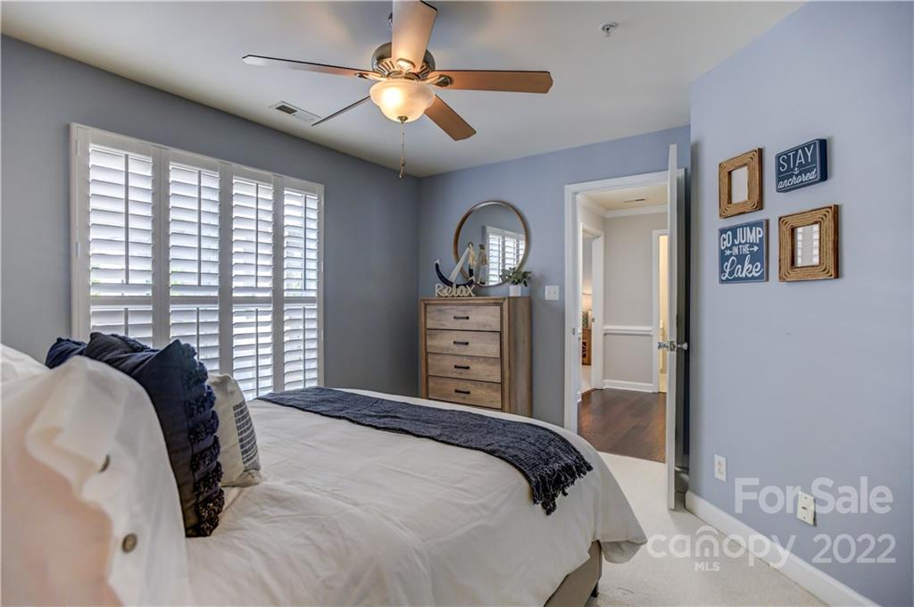 18537 Harborside Drive, Unit 9 Cornelius, NC 28031 - Photo 13 of 14 a bedroom with a bed and a chandelier