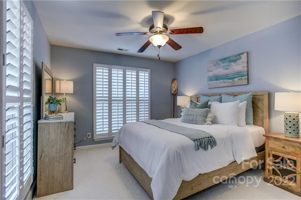 18537 Harborside Drive, Unit 9 Cornelius, NC 28031 - Photo 14 of 14 a bedroom with a bed and a chandelier