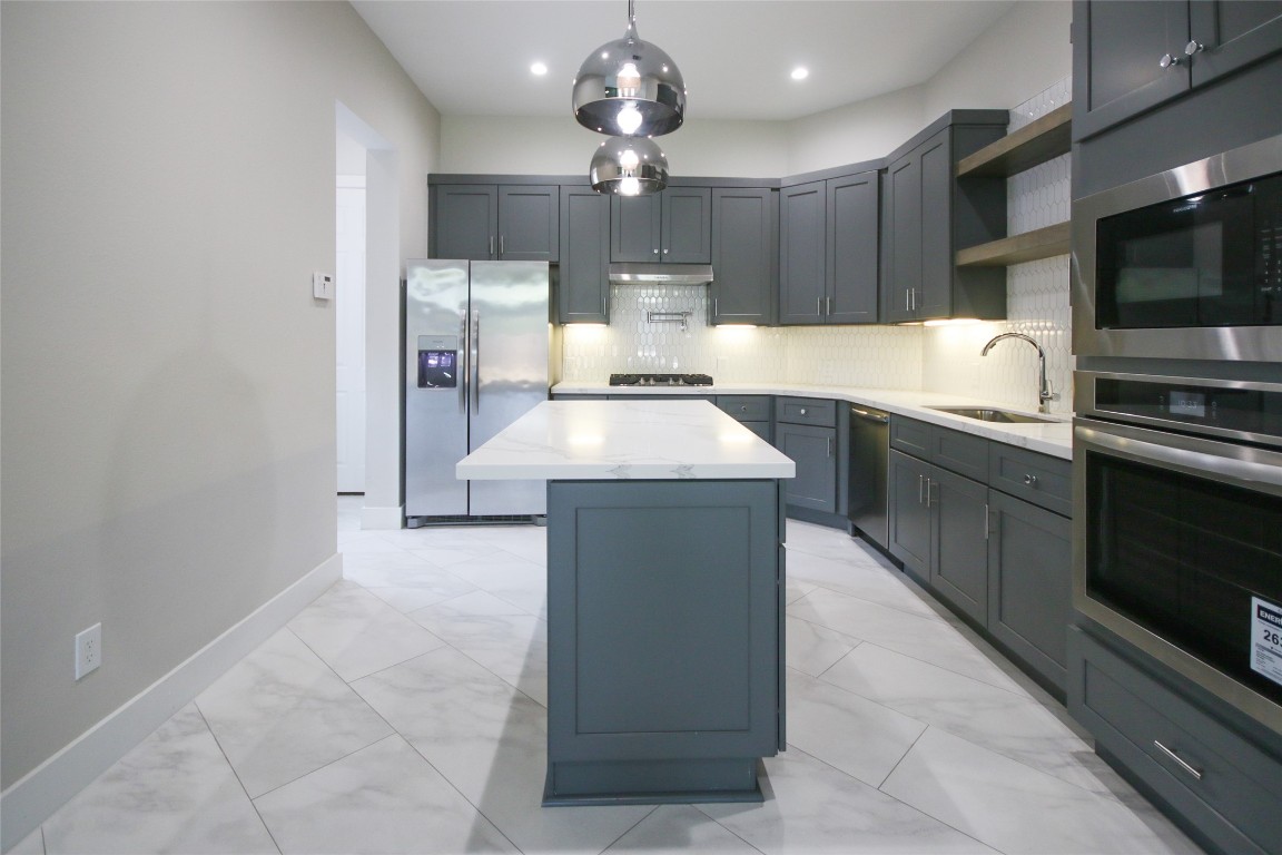 5113 Hershe Street, Unit B Houston, TX 77020 - Photo 8 of 44 a large kitchen with granite countertop a stove top oven a sink dishwasher and a microwave oven on the blue kitchen countertops