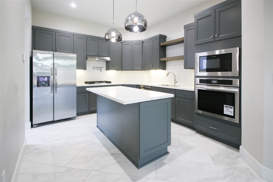 5113 Hershe Street, Unit B Houston, TX 77020 - Photo 9 of 44 a kitchen with stainless steel appliances a stove a sink and a refrigerator