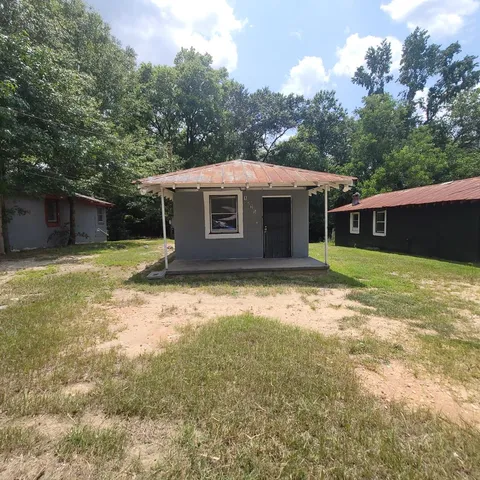 a front view of house with yard and trees in the background