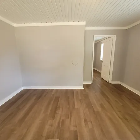 a view of an empty room with wooden floor