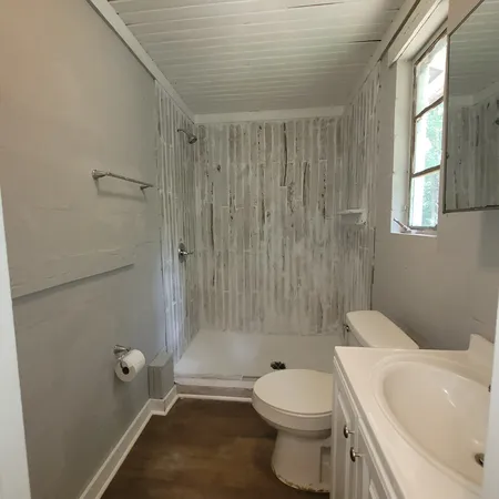 a white toilet sitting next to a bath tub shower