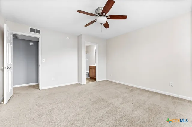 an empty room with a window and a ceiling fan